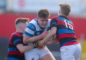 Rockwell’s Brian Gleeson is tackled by James O’Brien and Harry Bennis of St. Munchin’s.