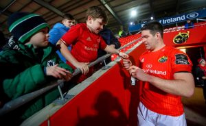 Billy Holland signs autographs for fans after the game.