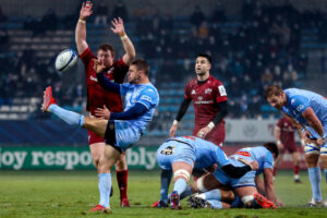 Rory Kockott kicks a box kick past Stephen Archer.