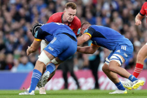 Rory Scannell is tackled by Caelan Doris and Scott Penny.